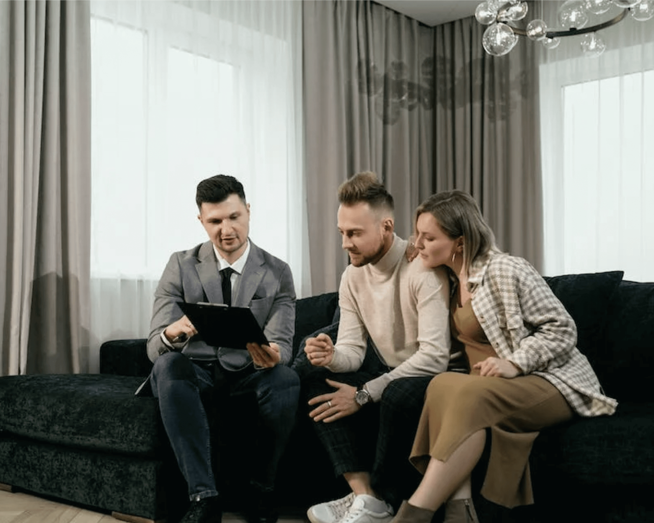 Smartly dressed man showing a couple their solar options sitting on a luxurious couch