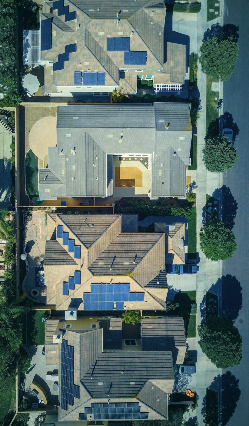 Residential neighbourhood aerial view of their rooftops lined with solar panels
