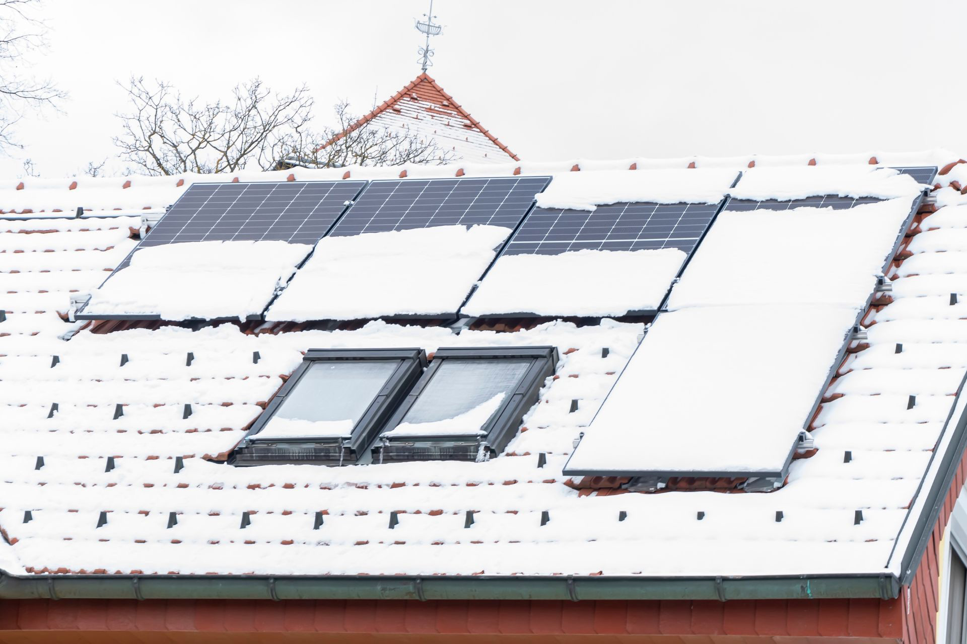 A home with solar panel photovoltaic cells covered in snow